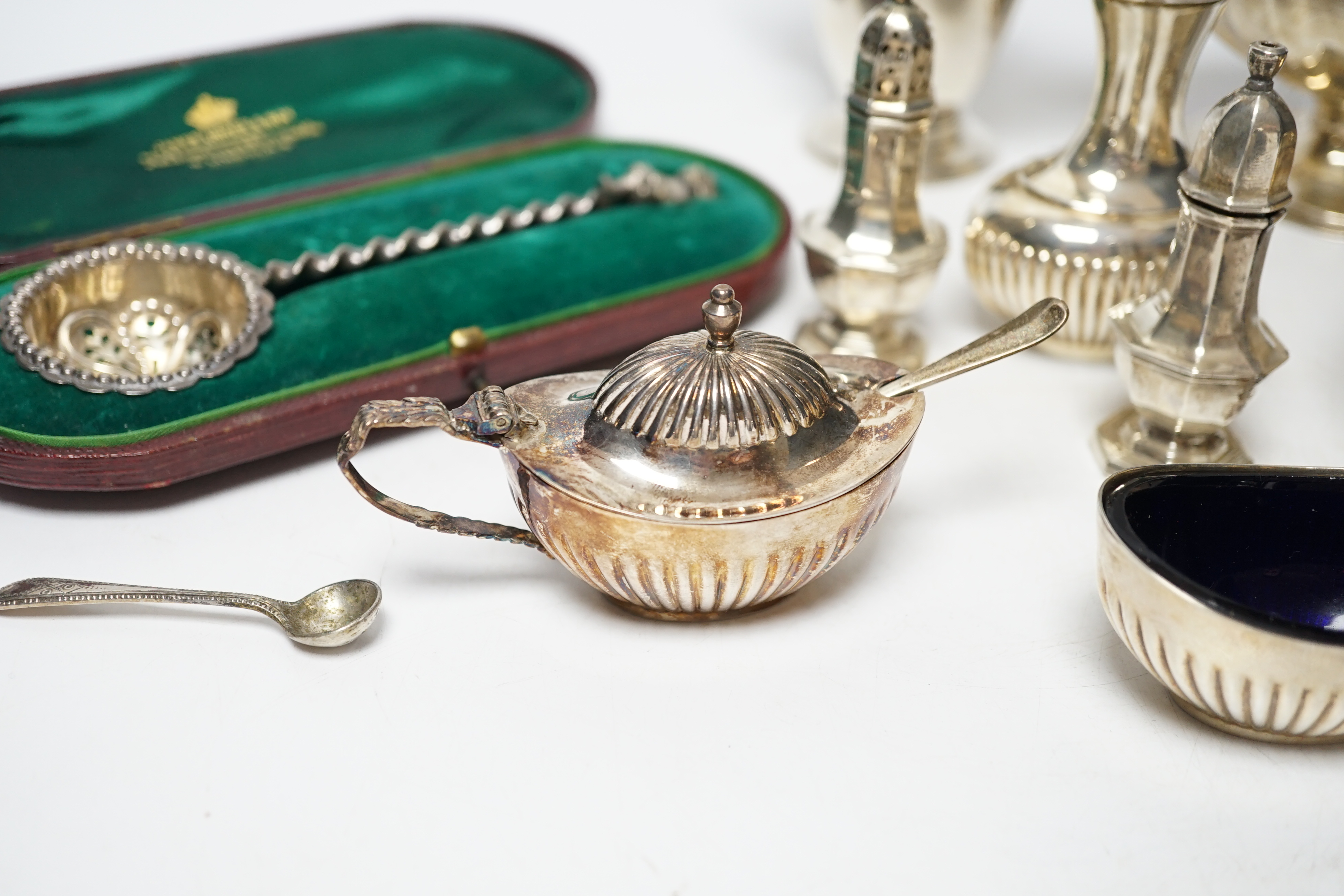 A group of small silver including Edwardian silver oval sugar basket, a modern silver cream jug and sugar bowl, five assorted condiments, a silver sifter spoon and a late Victorian scent bottle, 56mm.